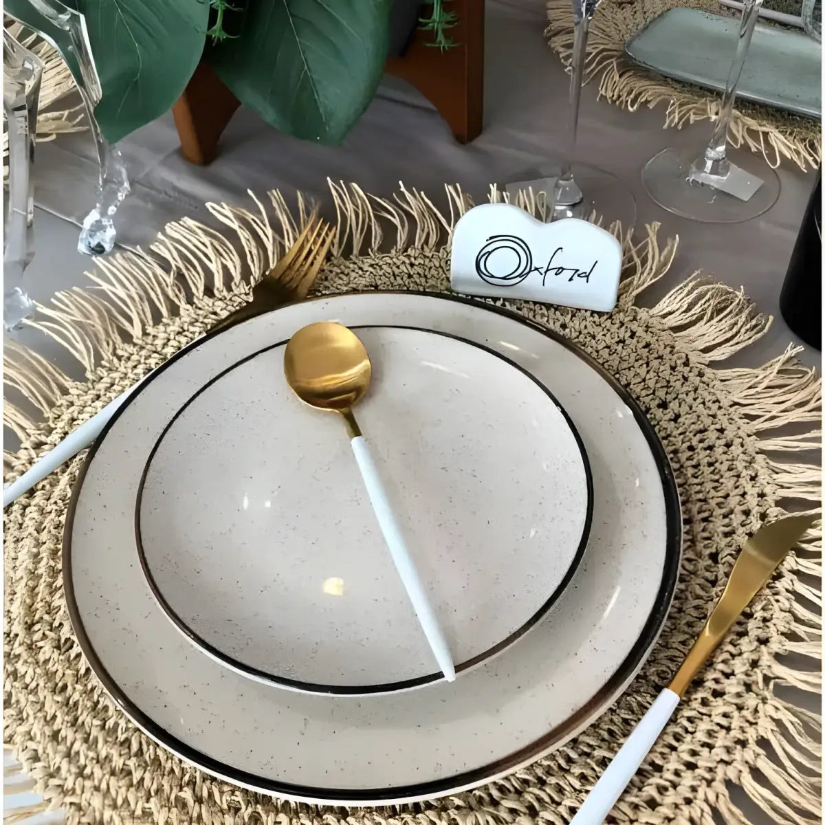 Conjunto elegante de pratos com talheres dourados e brancos.