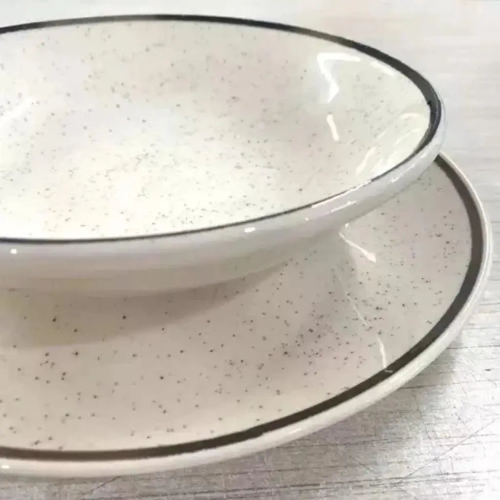 Tigela e pires de cerâmica salpicada com acabamento escuro.