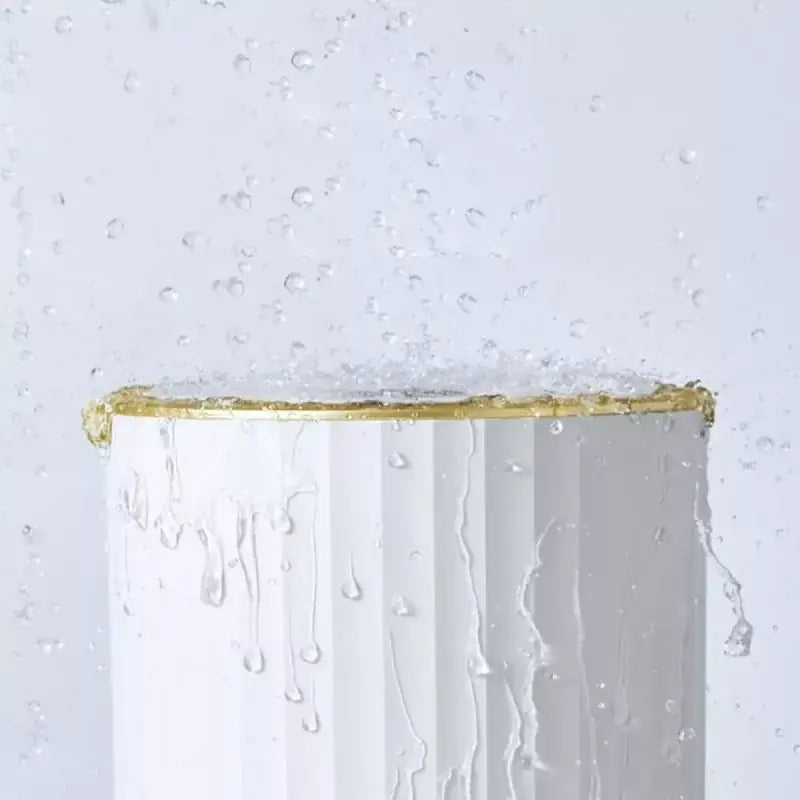 Lixeira banheiro automática inteligente 9L redonda com cilindro branco e detalhes dourados sob spray de água