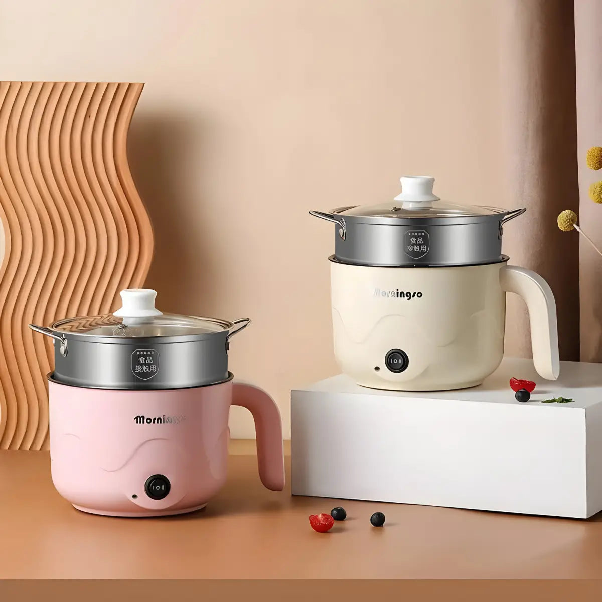 Dois hot pots elétricos multifuncionais com cestos de vapor em frente ao produto Ricaly