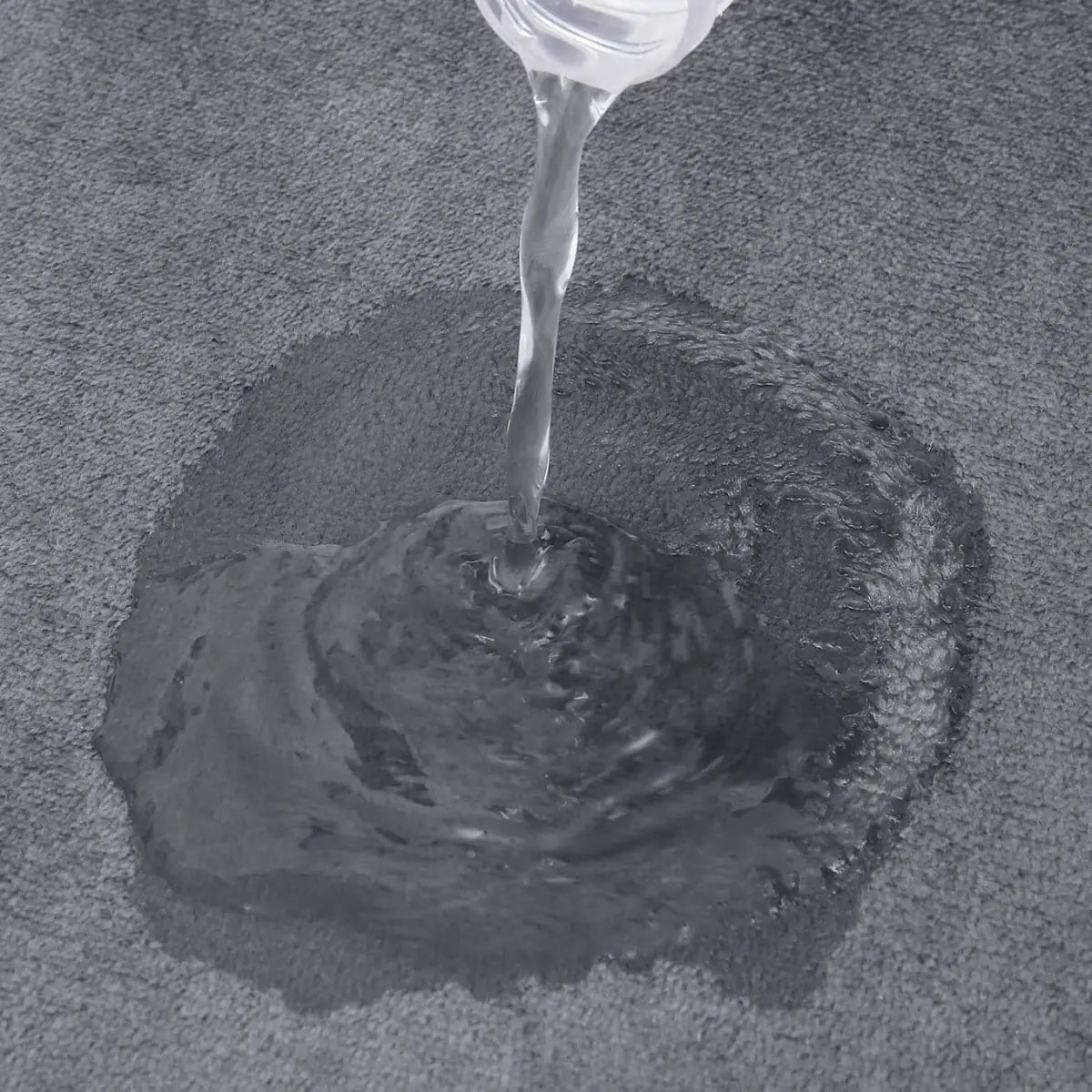 Água sendo despejada sobre tecido cinza do Tapete Banheiro Microfibra Antiderrapante Ricaly